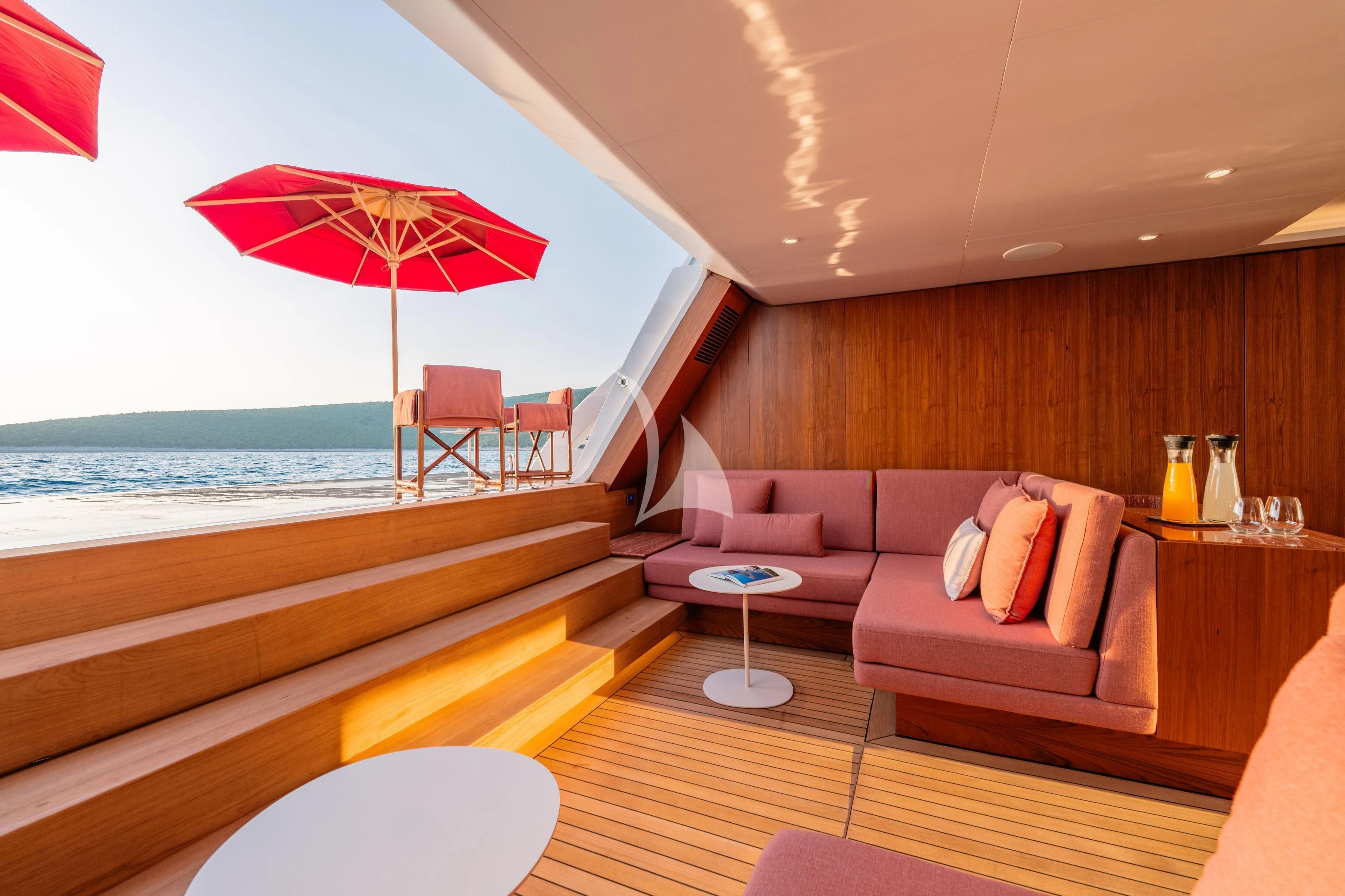 a room with a couch and a table and umbrella aboard TIREA Yacht for Sale