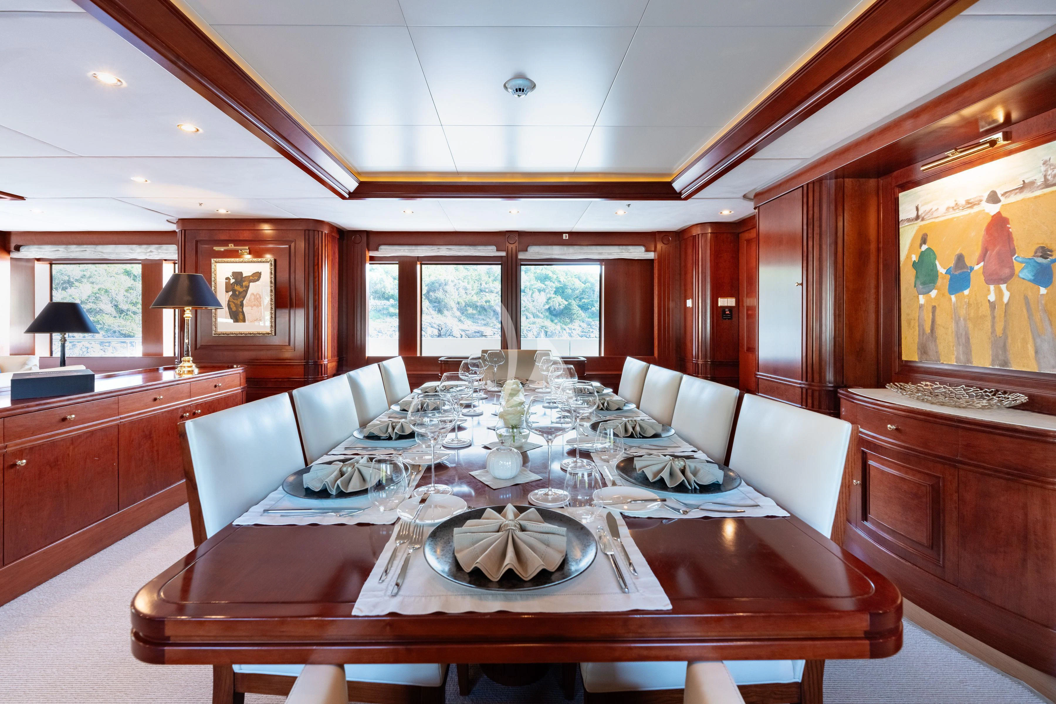 a large living room with a large white couch and a large dining table aboard TIREA Yacht for Sale