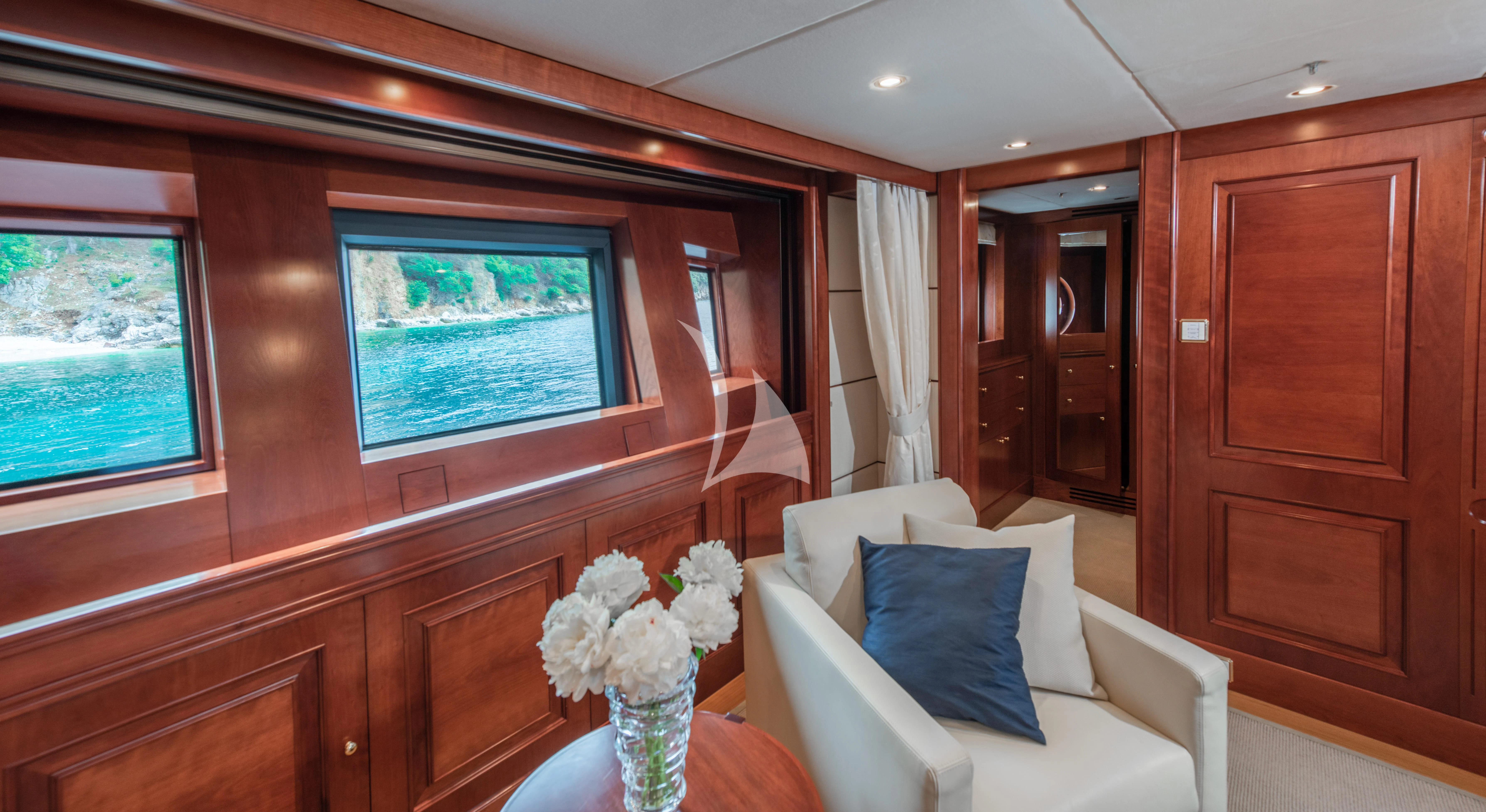 a room with a couch and a table with flowers in it aboard TIREA Yacht for Sale