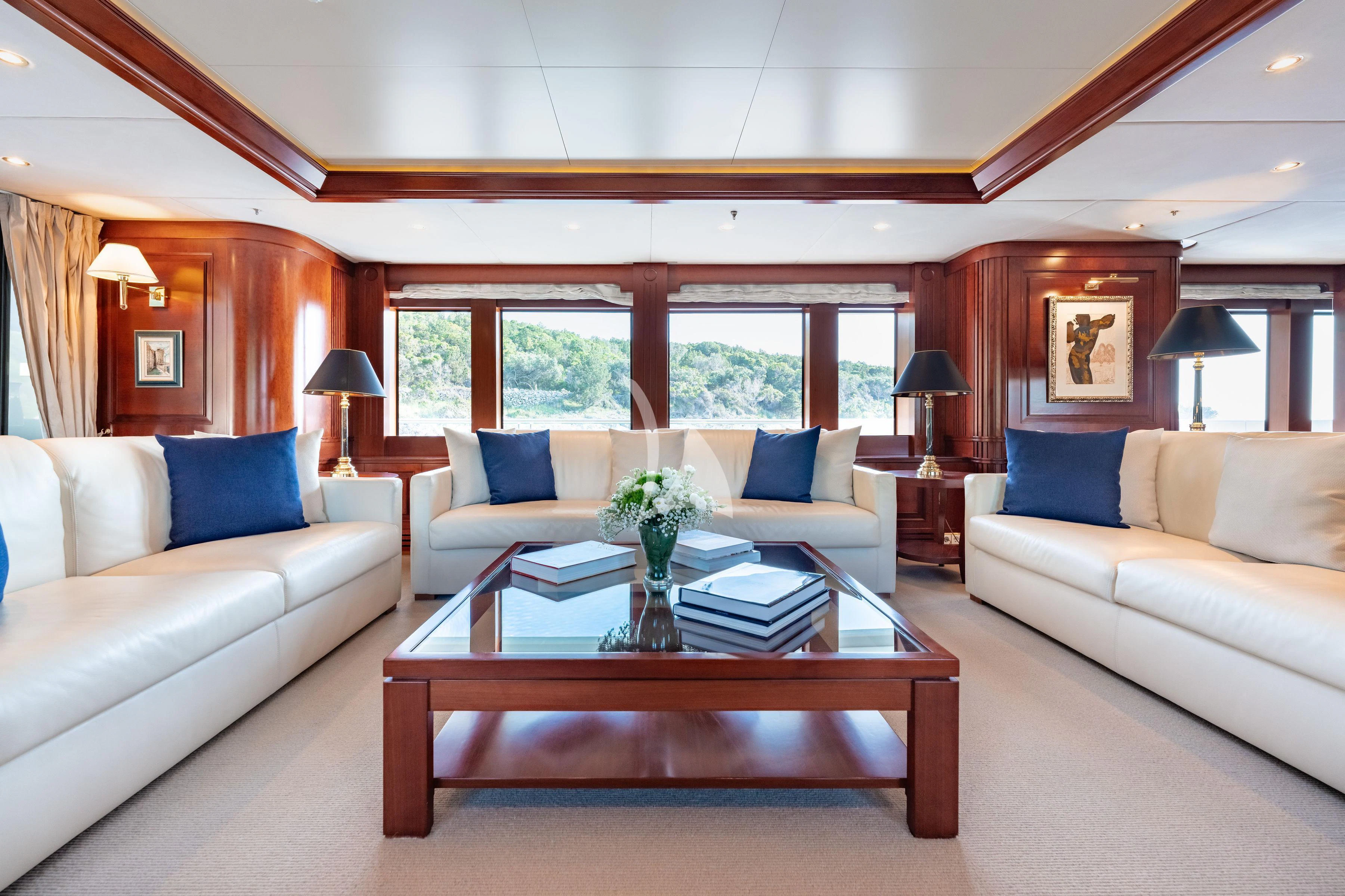 a living room with a table and couches aboard TIREA Yacht for Sale