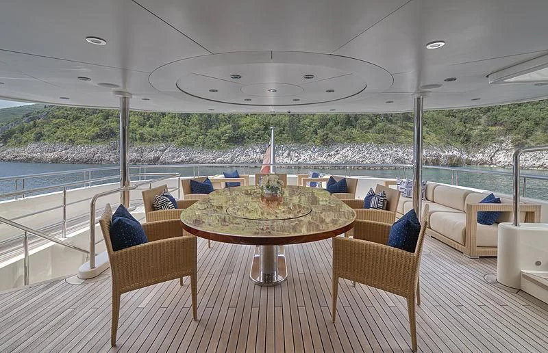 a table and chairs on a deck overlooking a body of water aboard TIREA Yacht for Sale