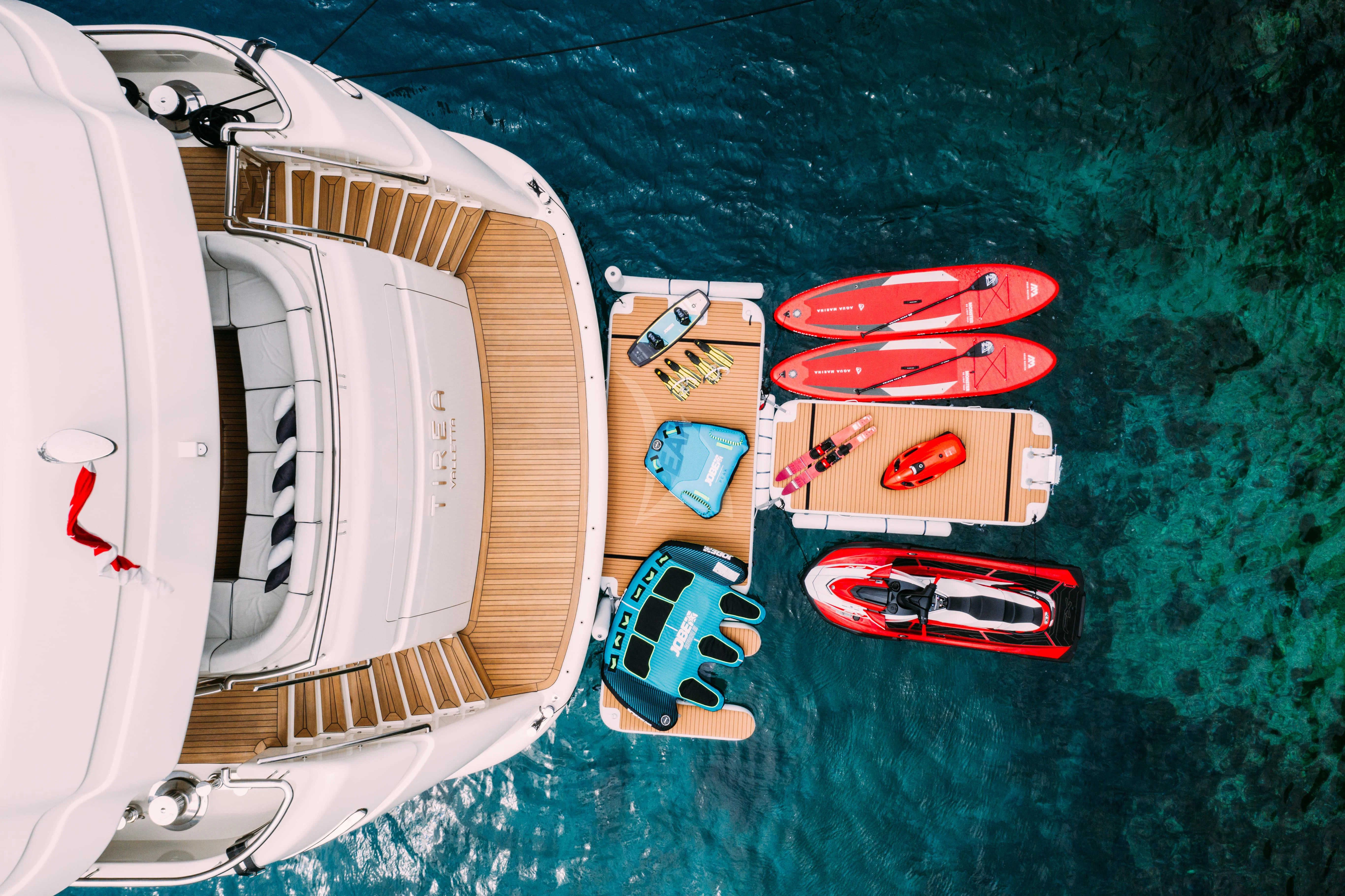 a group of red and white cars on a road aboard TIREA Yacht for Sale
