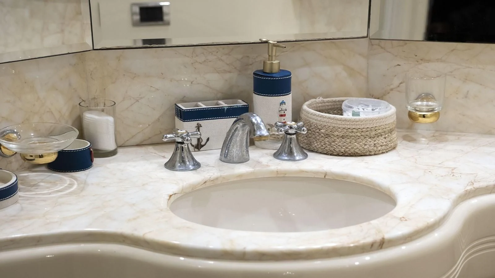 a bathroom sink with soap bottles and a basket on the counter aboard TITAN Yacht for Sale