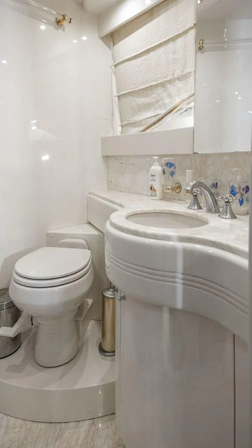 a bathroom with a toilet sink and a mirror aboard TITAN Yacht for Sale