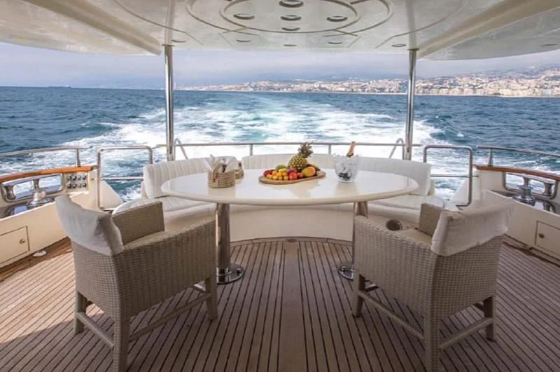 a table on a deck overlooking the ocean aboard TITAN Yacht for Sale