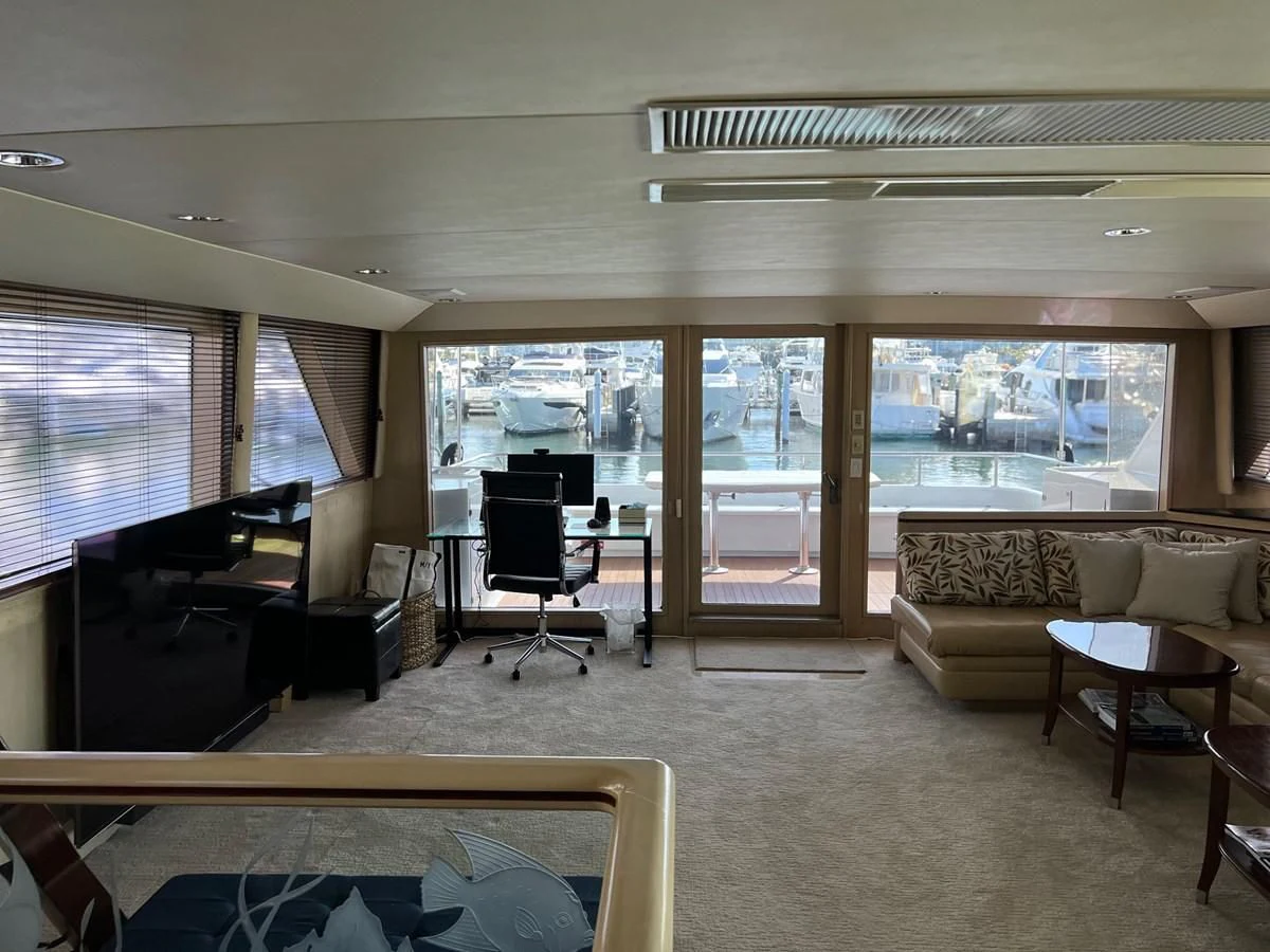 a living room with a piano and a large window aboard K Yacht for Sale