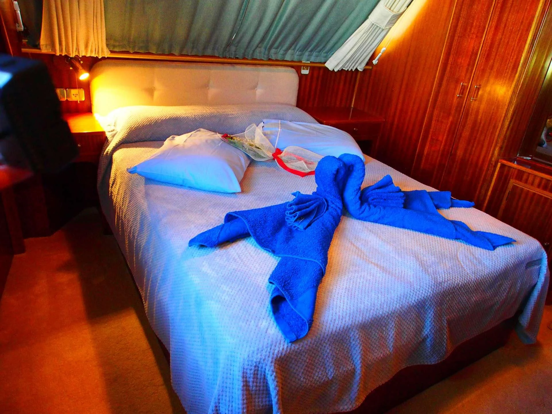 a bed with blue sheets aboard K Yacht for Sale