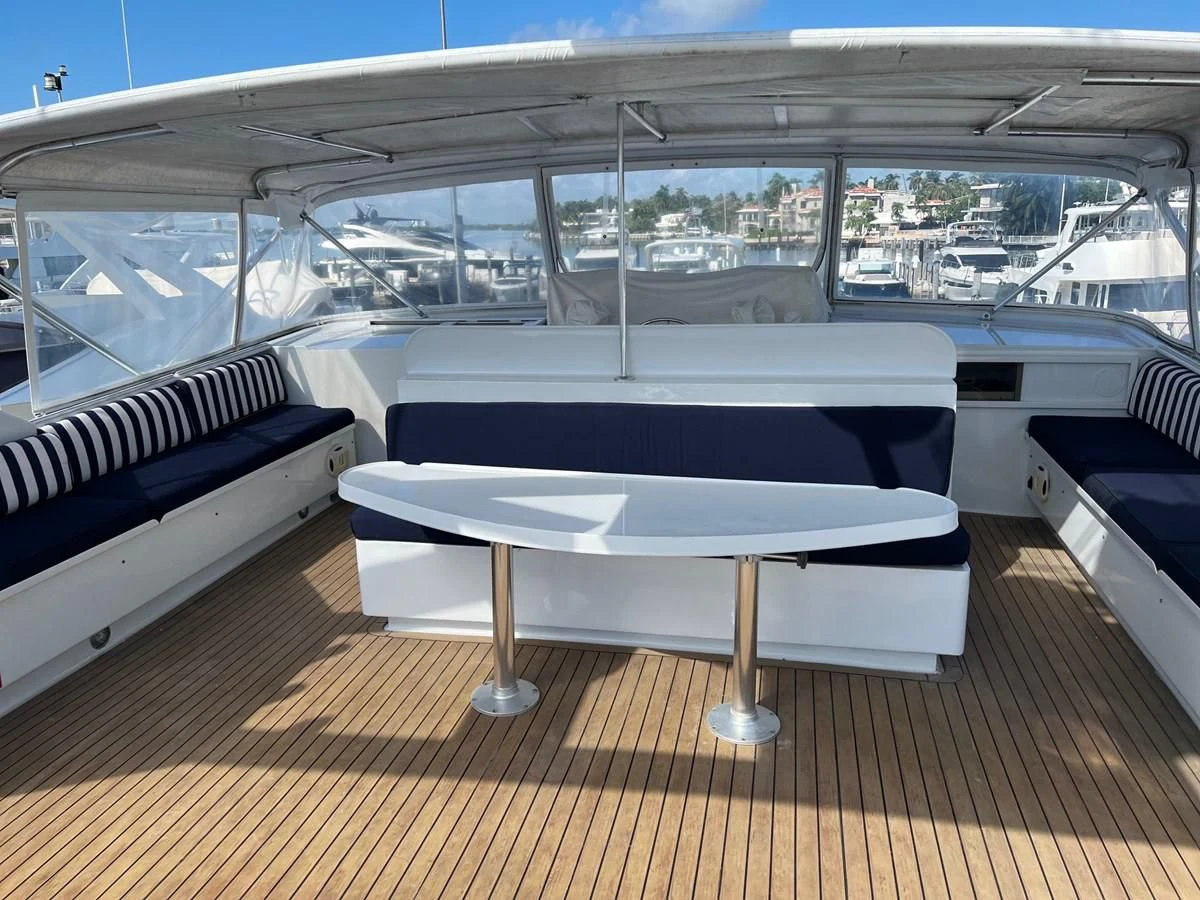 a table and couch on a deck aboard K Yacht for Sale