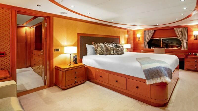 a bedroom with a bed and a dresser aboard PLEIADES II Yacht for Sale