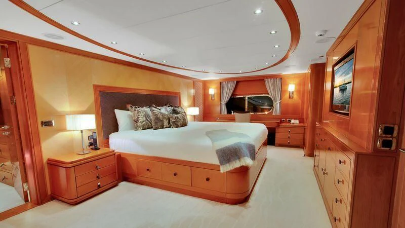 a bedroom with a bed and a dresser aboard PLEIADES II Yacht for Sale