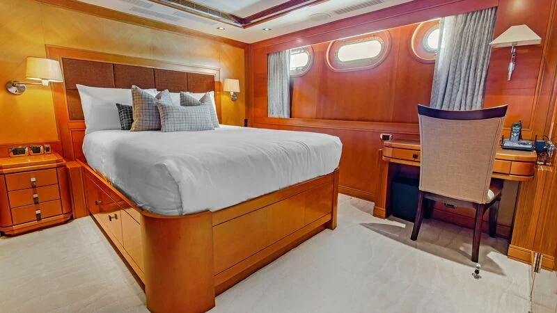 a room with a bed and a chair aboard PLEIADES II Yacht for Sale
