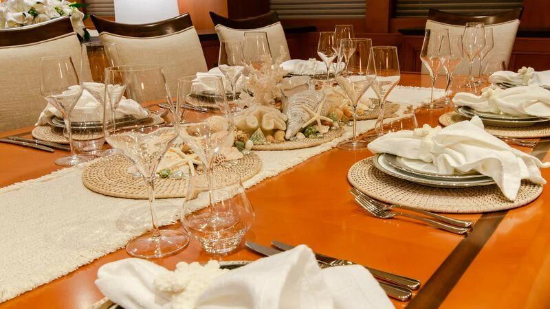 a table set with plates and glasses aboard PLEIADES II Yacht for Sale