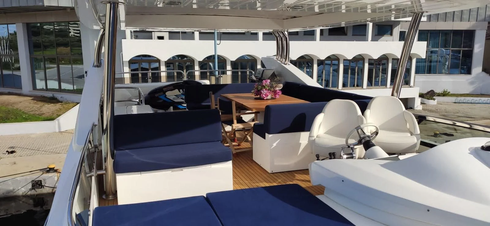a deck with a table chairs and a large window aboard FAMILY SPIRIT Yacht for Sale