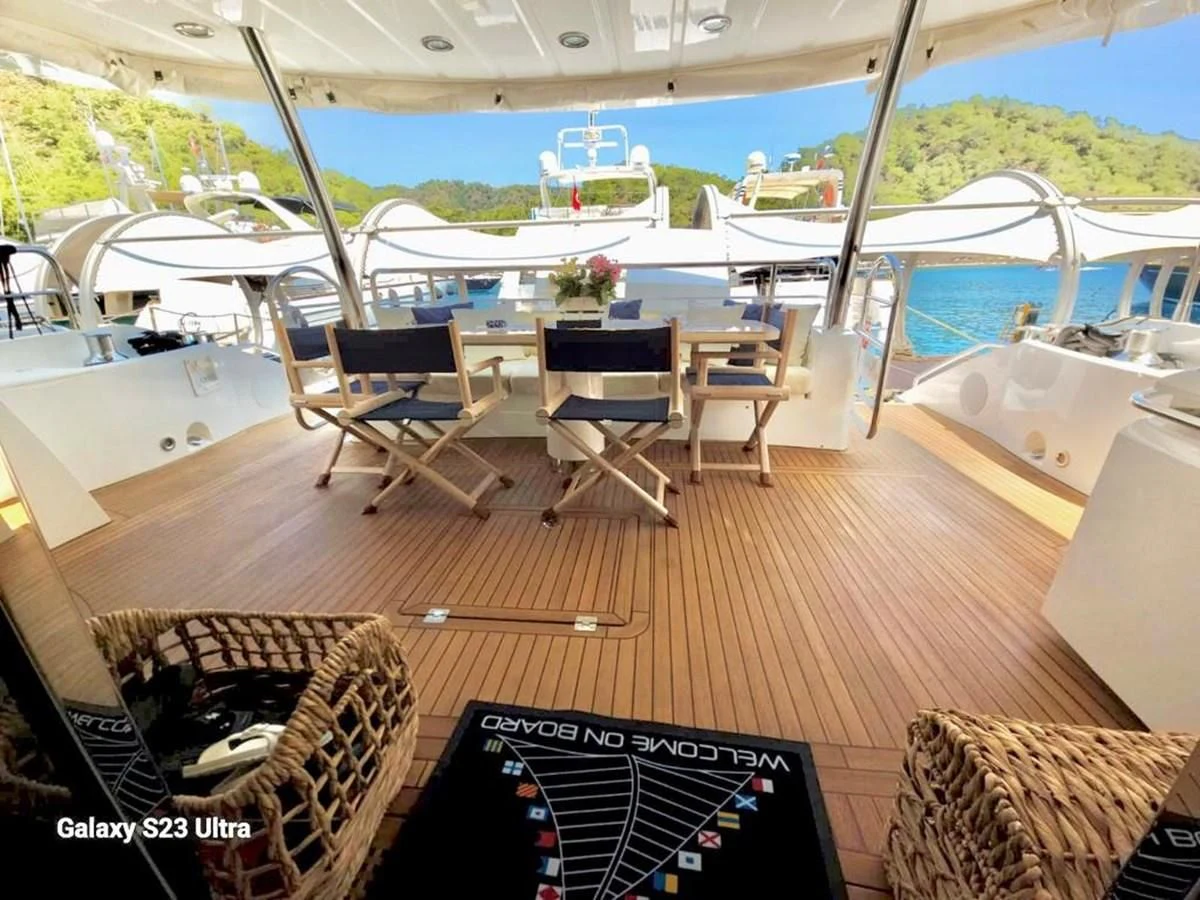 a deck with a table and chairs on it aboard FAMILY SPIRIT Yacht for Sale