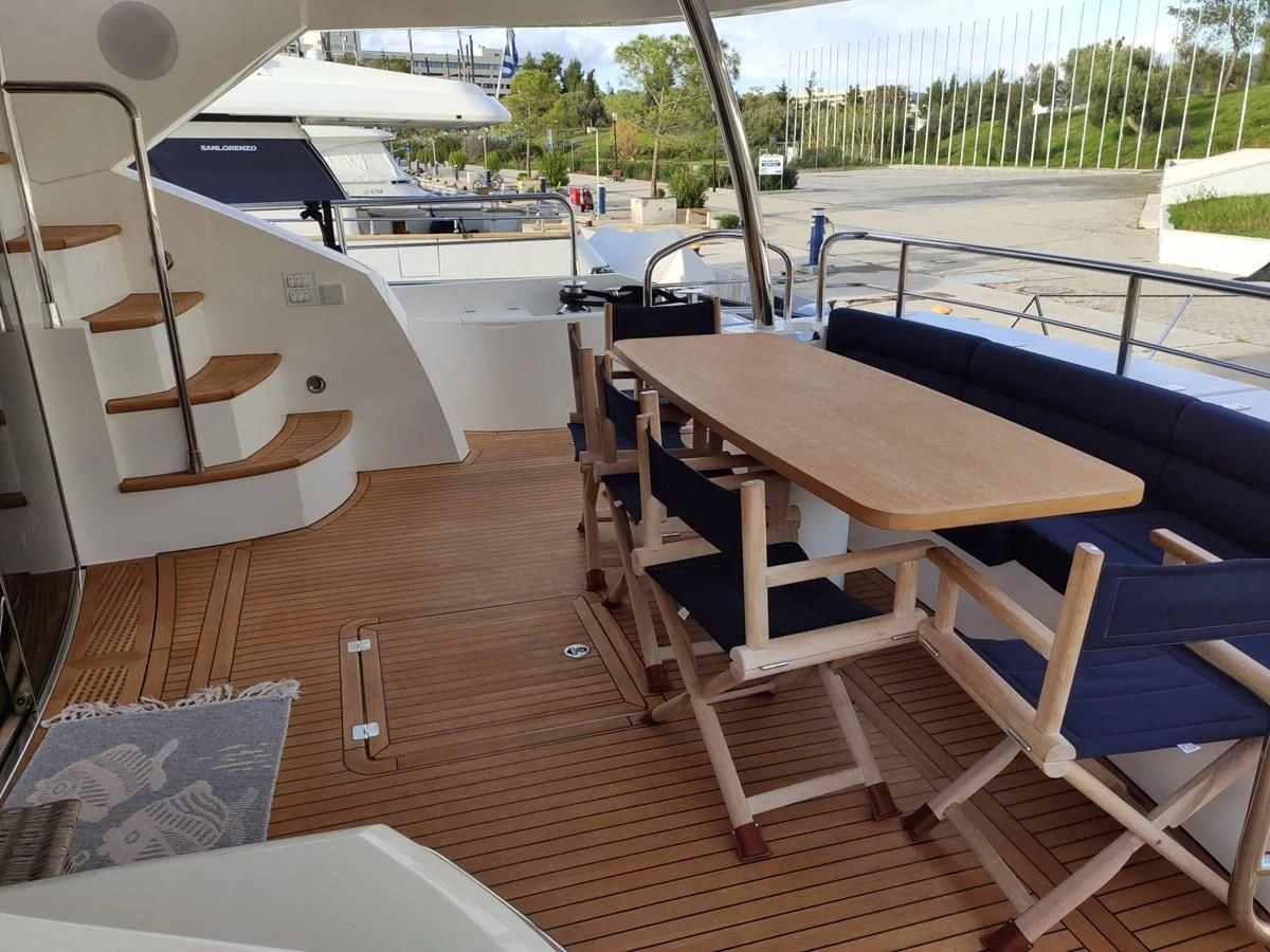a deck with a table and chairs aboard FAMILY SPIRIT Yacht for Sale