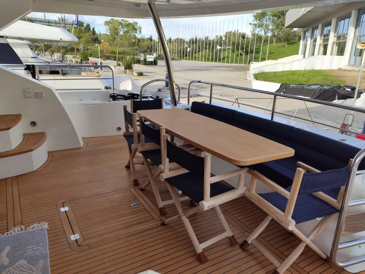a deck with a table and chairs aboard FAMILY SPIRIT Yacht for Sale