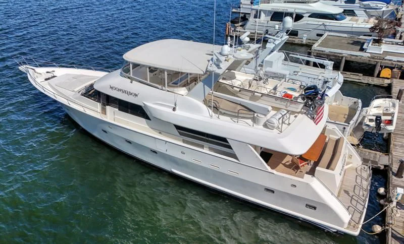 a white yacht docked at a pier aboard MOONSHADOW Yacht for Sale