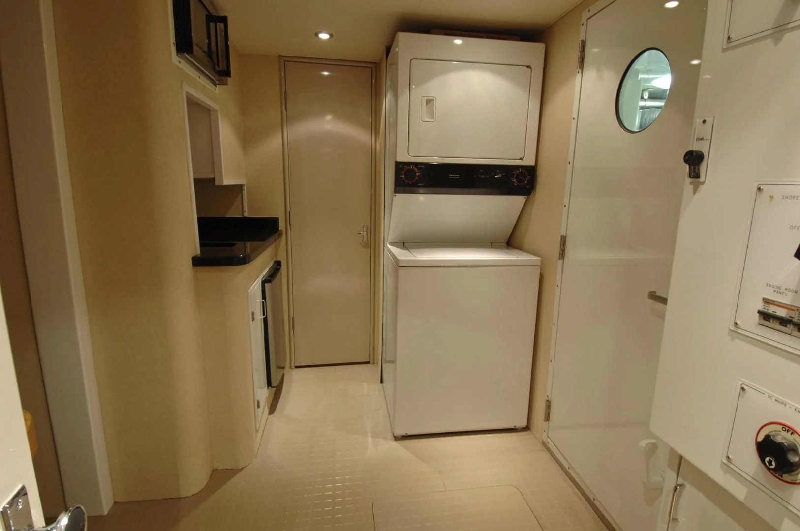 a room with a refrigerator and cabinets aboard MOONSHADOW Yacht for Sale