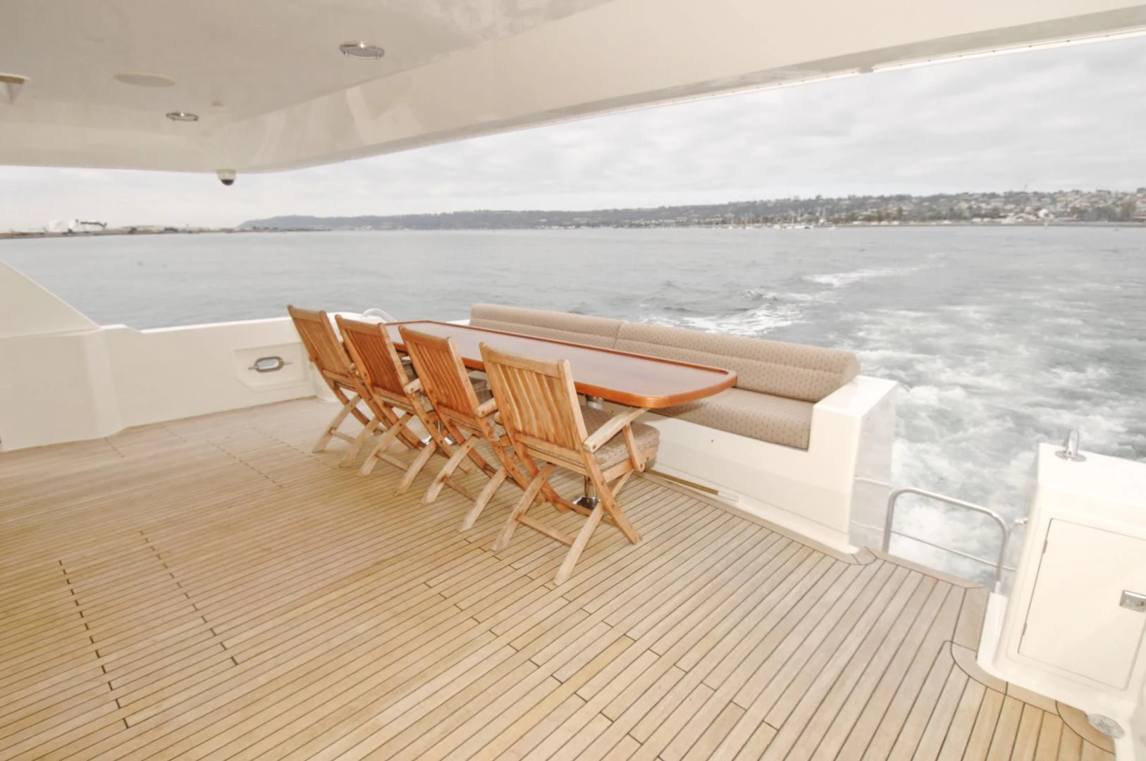 a deck with chairs and a table on it aboard MOONSHADOW Yacht for Sale