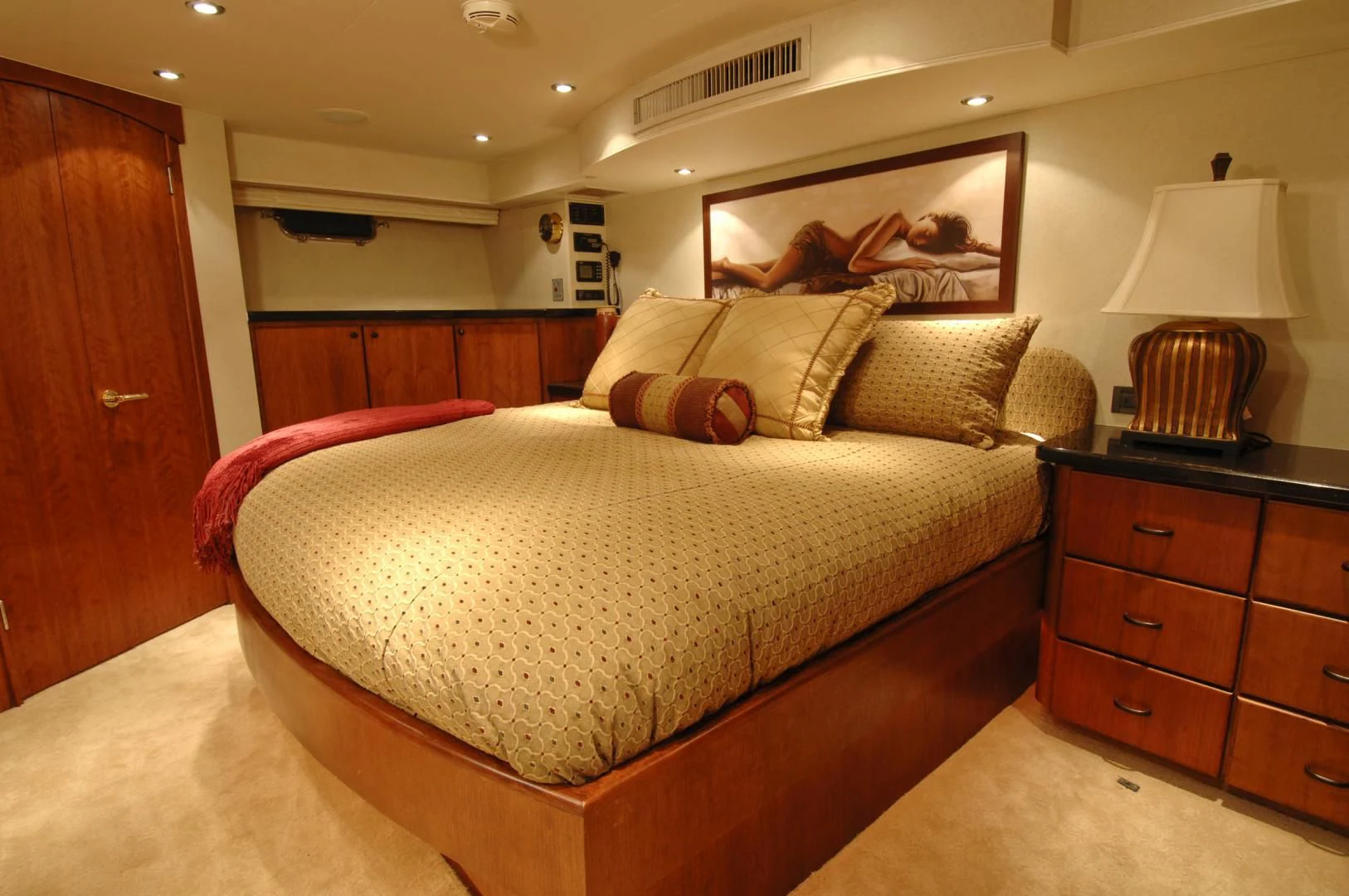 a bedroom with a bed and a lamp aboard MOONSHADOW Yacht for Sale