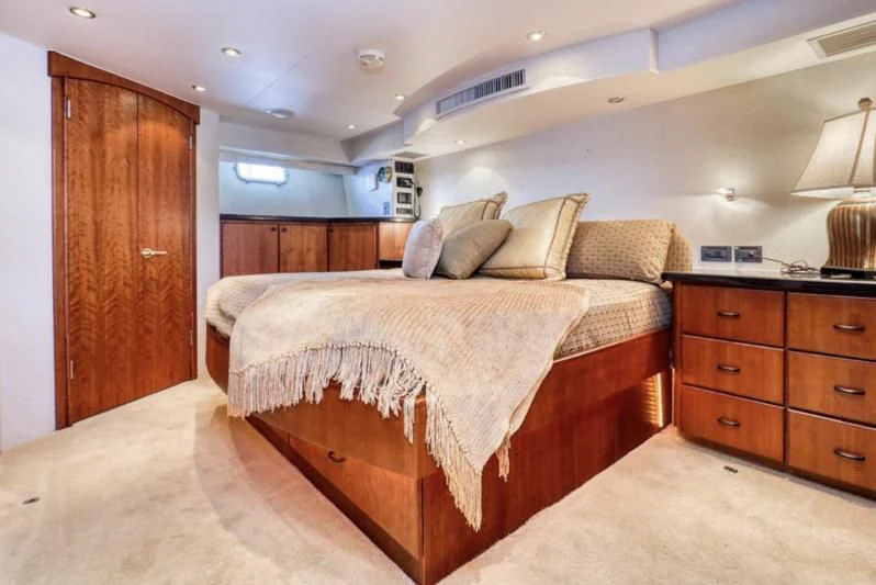 a bedroom with a bed and a wood door aboard MOONSHADOW Yacht for Sale