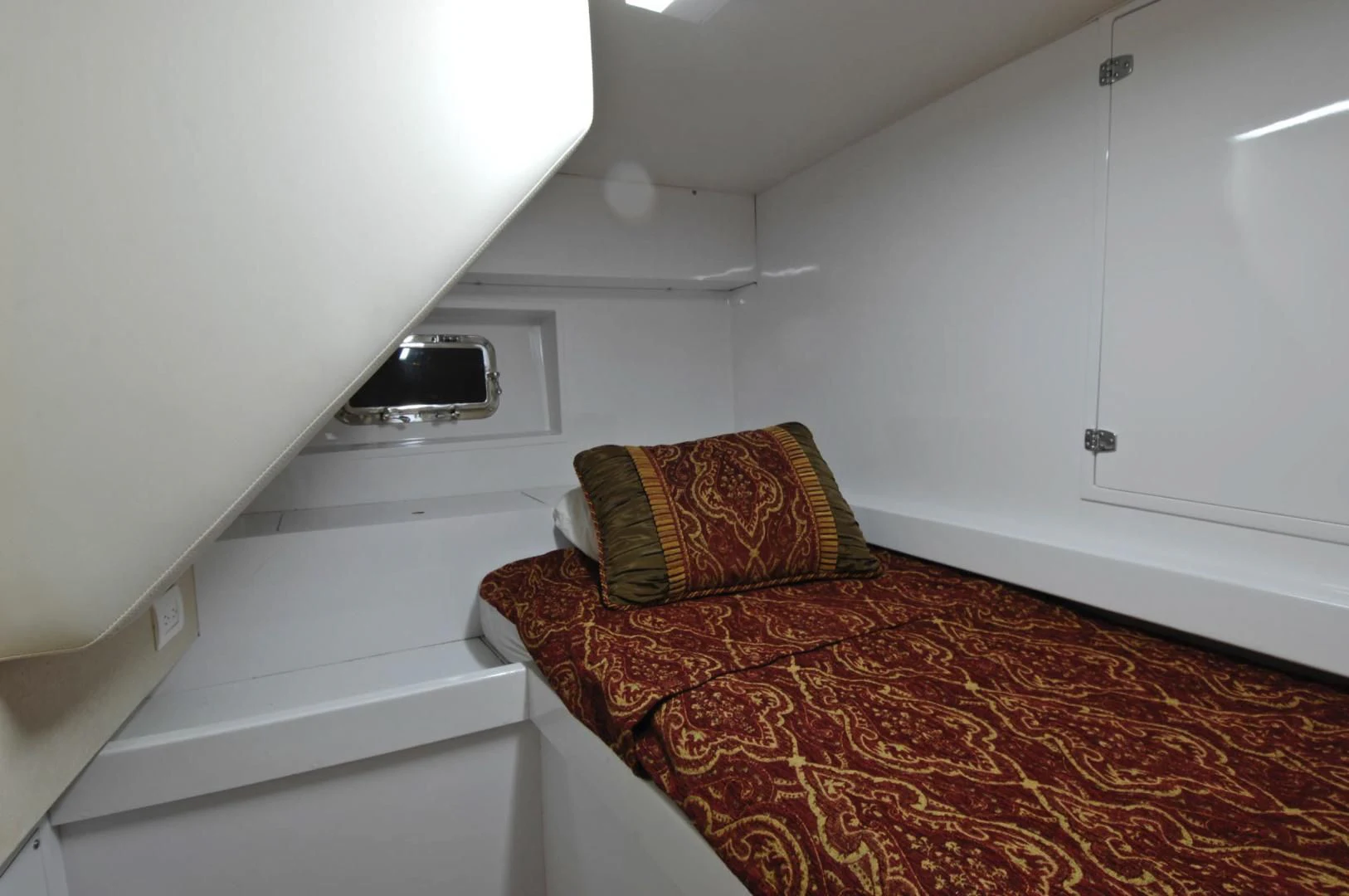 a bed with a red and yellow rug on it aboard MOONSHADOW Yacht for Sale