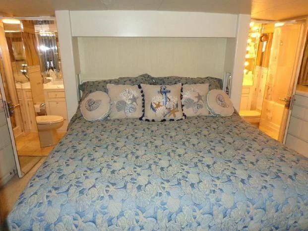 a bed with blue sheets aboard YACHTS A LUCK Yacht for Sale