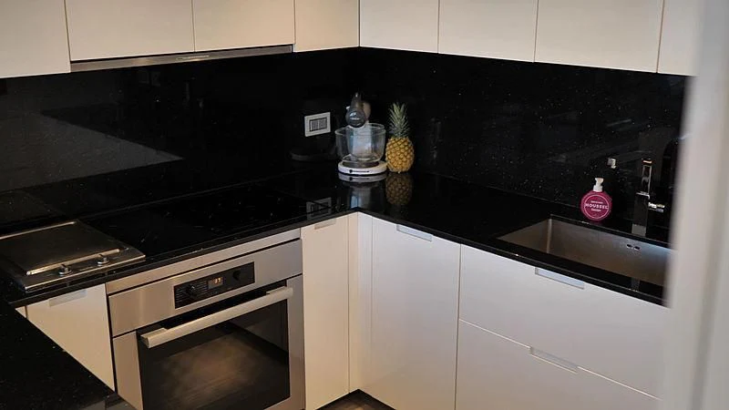 a kitchen with black cabinets aboard THIRTY EIGHT Yacht for Sale