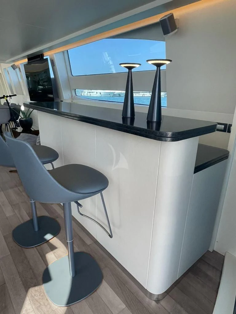 a black and white table with stools and a black bar on it aboard EVA Yacht for Charter