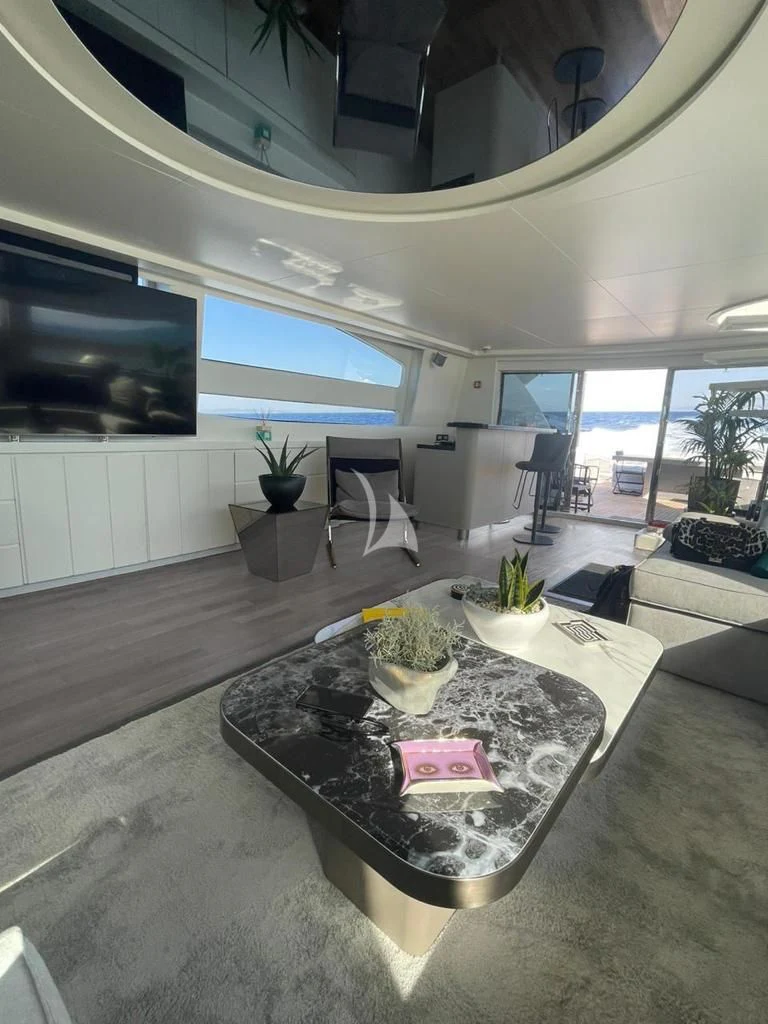 a living room with a large flat screen tv and a table aboard EVA Yacht for Charter