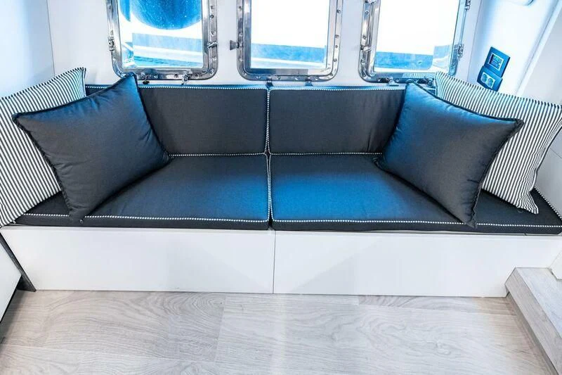 a couch with pillows aboard EVA Yacht for Charter