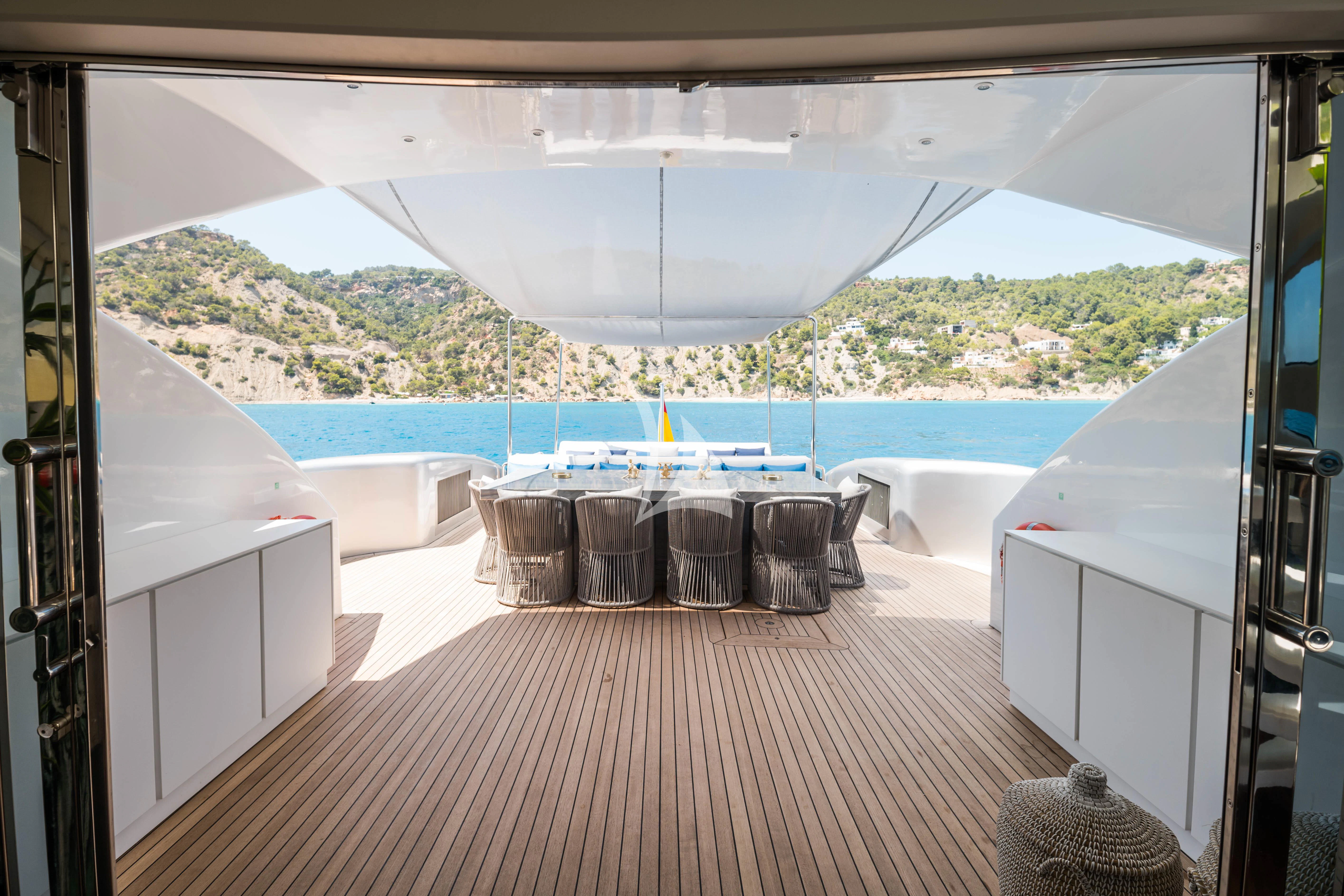 a room with a table and chairs and a large body of water aboard EVA Yacht for Charter