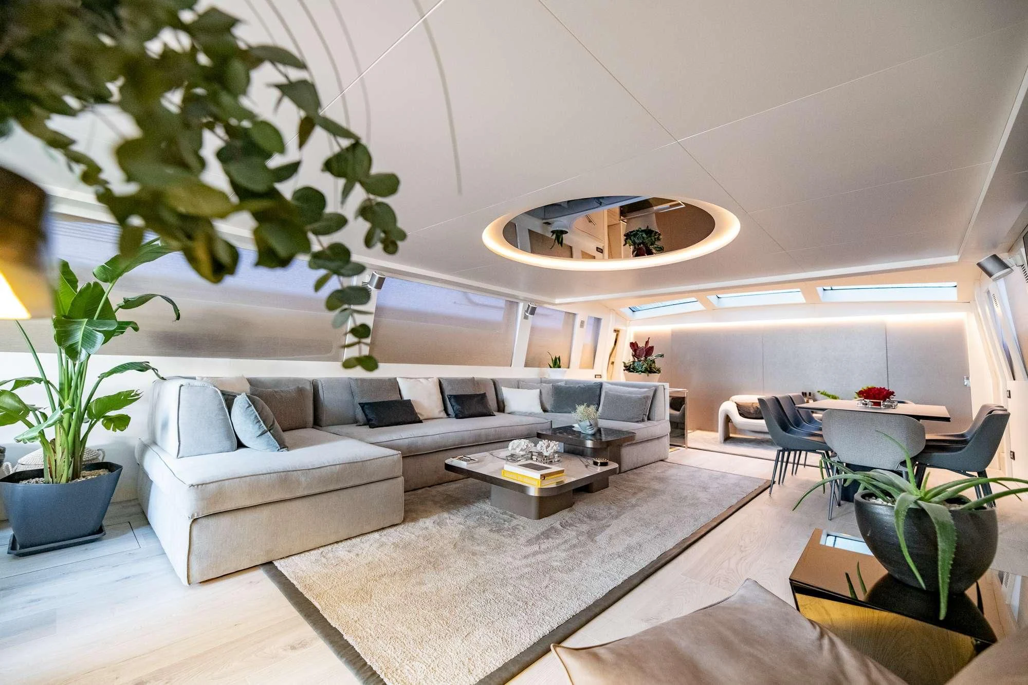 a living room with a large white sofa and a round table aboard EVA Yacht for Charter