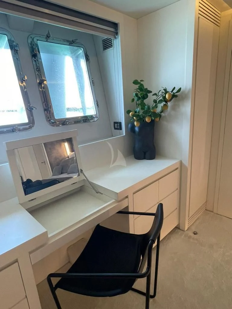 a small white desk with a chair and a television aboard EVA Yacht for Charter