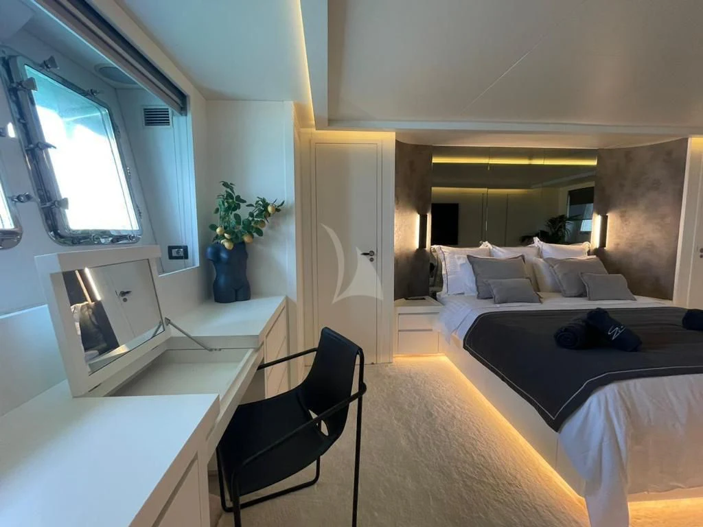 a room with a bed and a desk aboard EVA Yacht for Charter