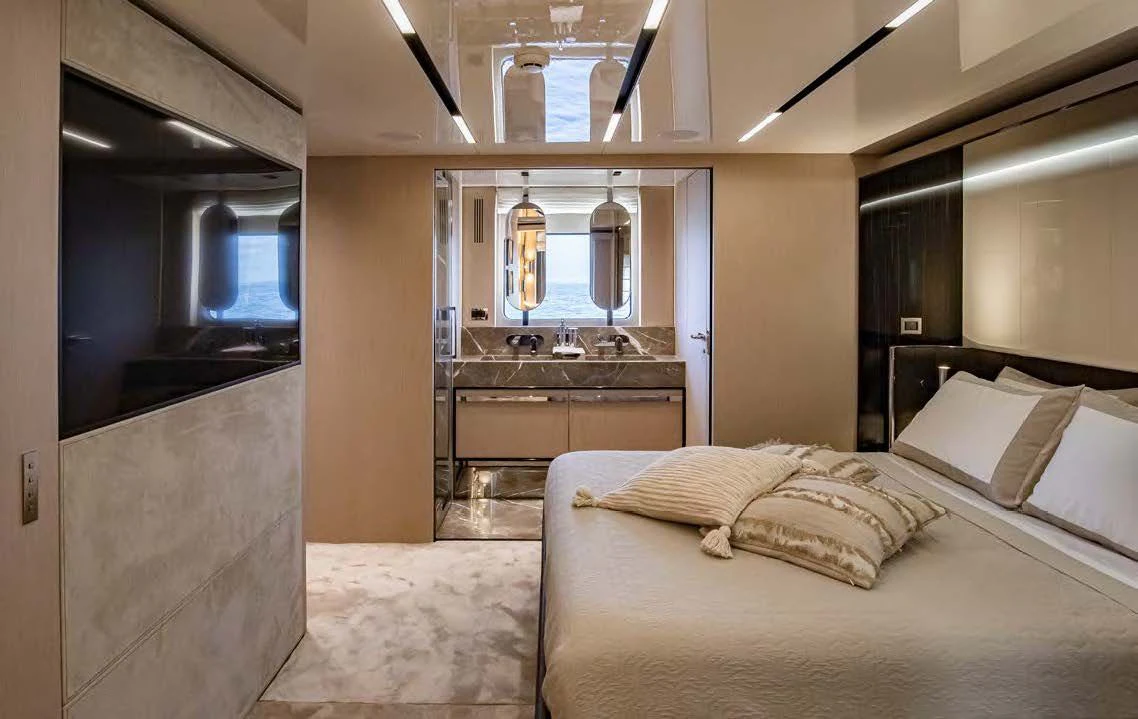 a bedroom with a bed and a large mirror aboard SESSANTASETTE 67 Yacht for Sale