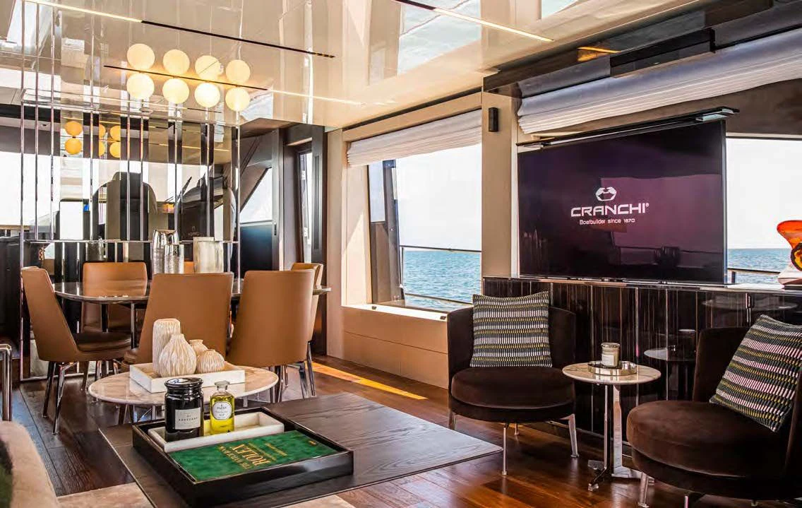 a room with a table chairs and a tv aboard SESSANTASETTE 67 Yacht for Sale