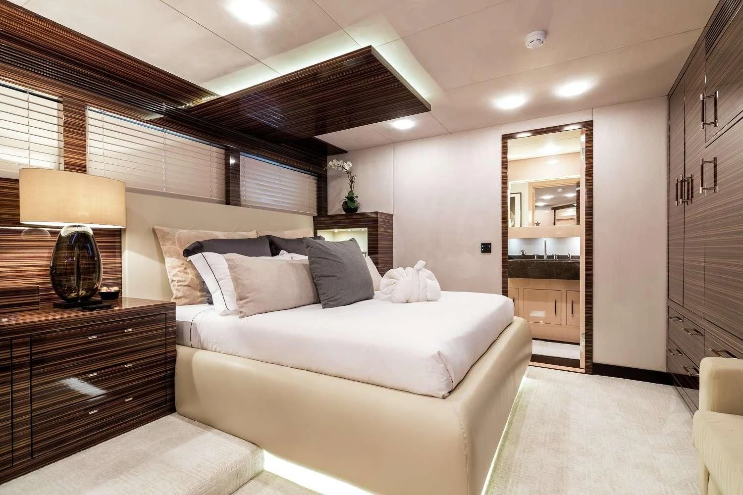 a bedroom with a bed and a lamp aboard GEMS 2 Yacht for Sale
