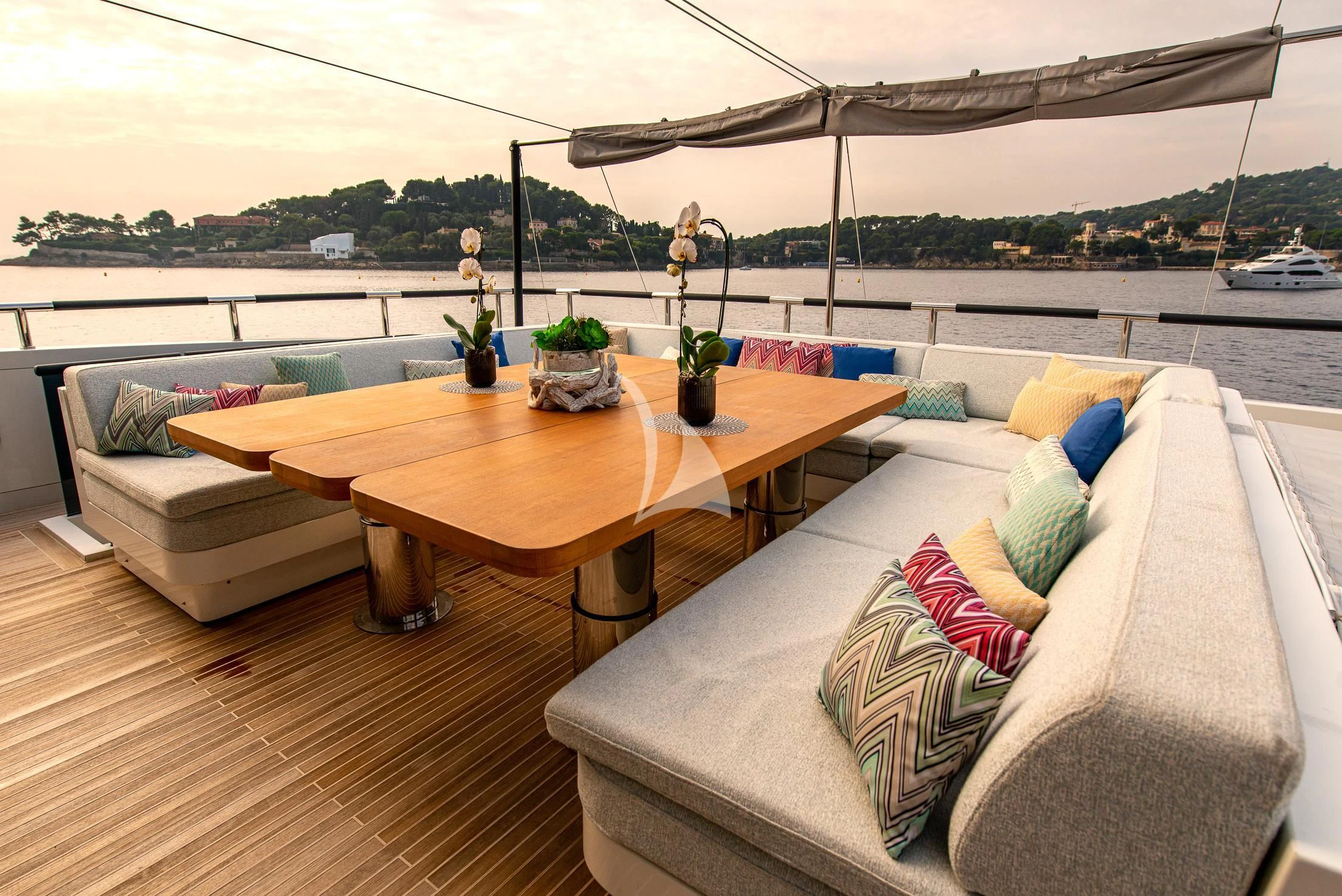 a table and couch on a deck aboard GEMS 2 Yacht for Sale