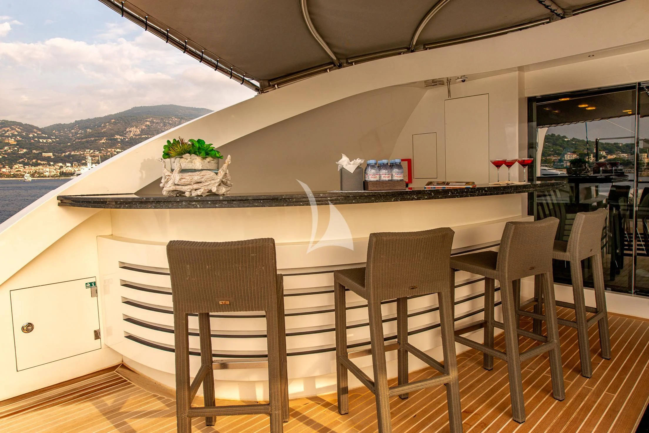 a large white dining table with chairs and a large white building with a view of the water and aboard GEMS 2 Yacht for Sale