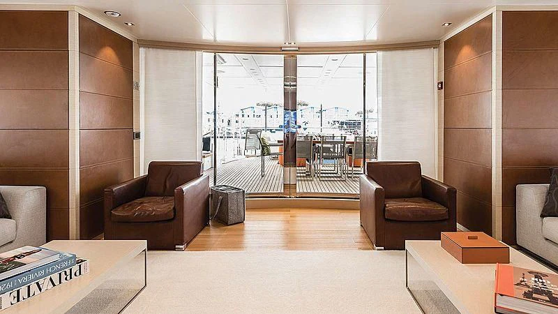 a room with a couch and a table and a view of a city aboard ABVIOS Yacht for Sale
