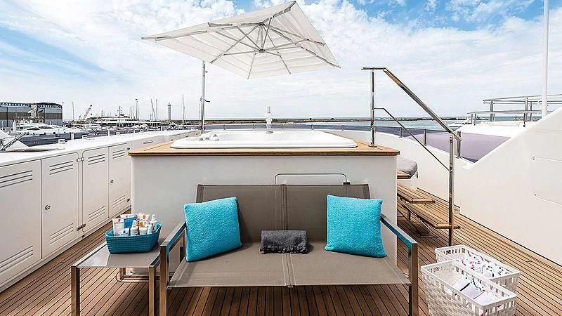 a deck with a table and chairs on it aboard ABVIOS Yacht for Sale