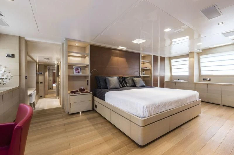 a large bedroom with a wood floor aboard ABVIOS Yacht for Sale