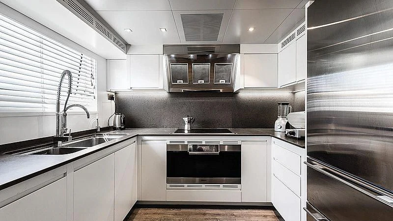 a kitchen with white cabinets aboard ABVIOS Yacht for Sale