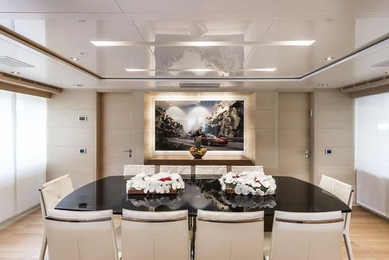 a dining table with white chairs aboard ABVIOS Yacht for Sale