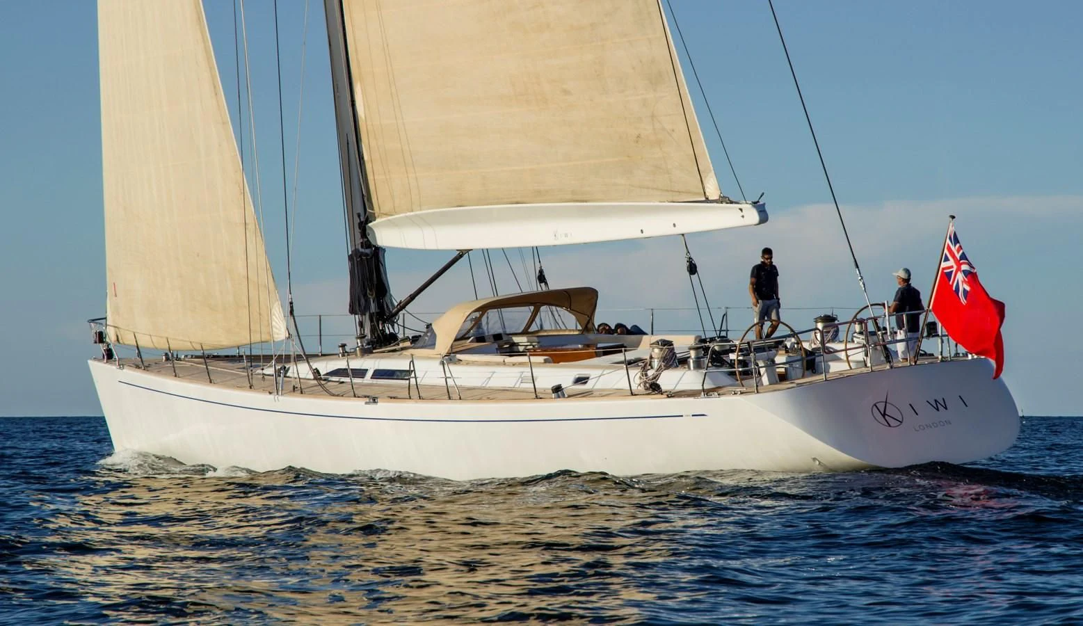 a sailboat with a flag on it aboard KIWI Yacht for Sale