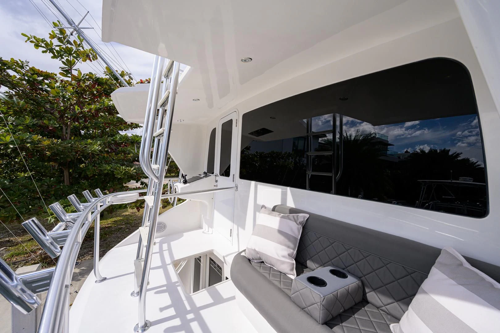 a white lounge chair on a deck overlooking a large flat screen television aboard KNOT RACING Yacht for Sale