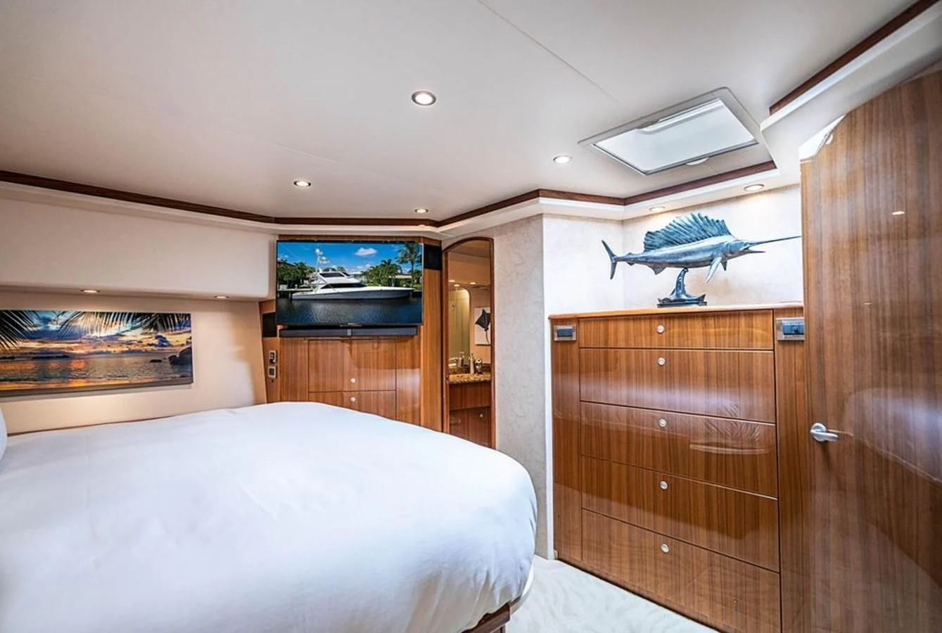 a bedroom with a bed and a wood cabinet aboard KNOT RACING Yacht for Sale