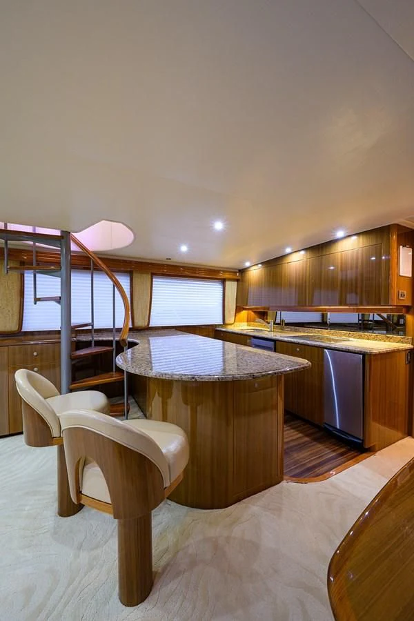 a kitchen with a bar stool and a table aboard KNOT RACING Yacht for Sale