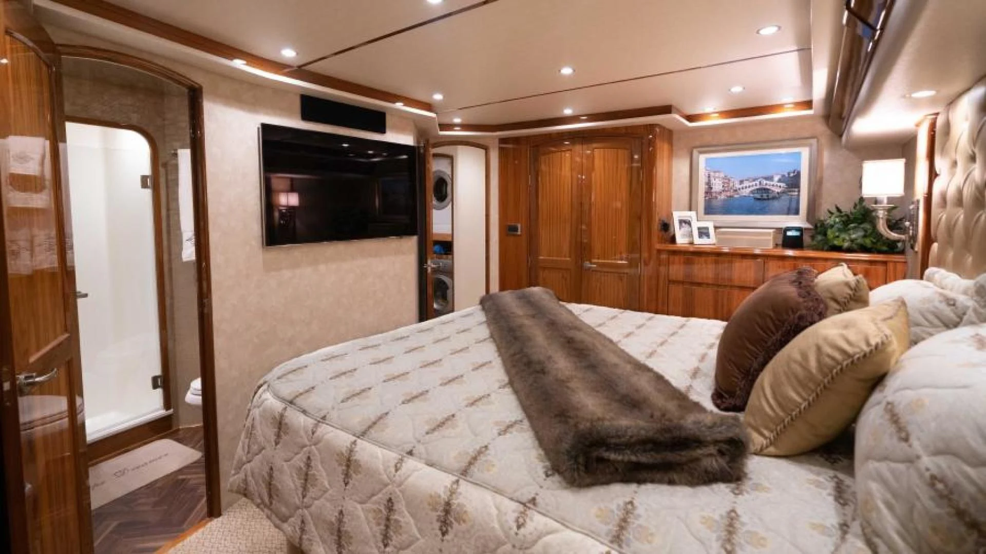 a bedroom with a bed and a television aboard NEVER TOO LATE Yacht for Charter